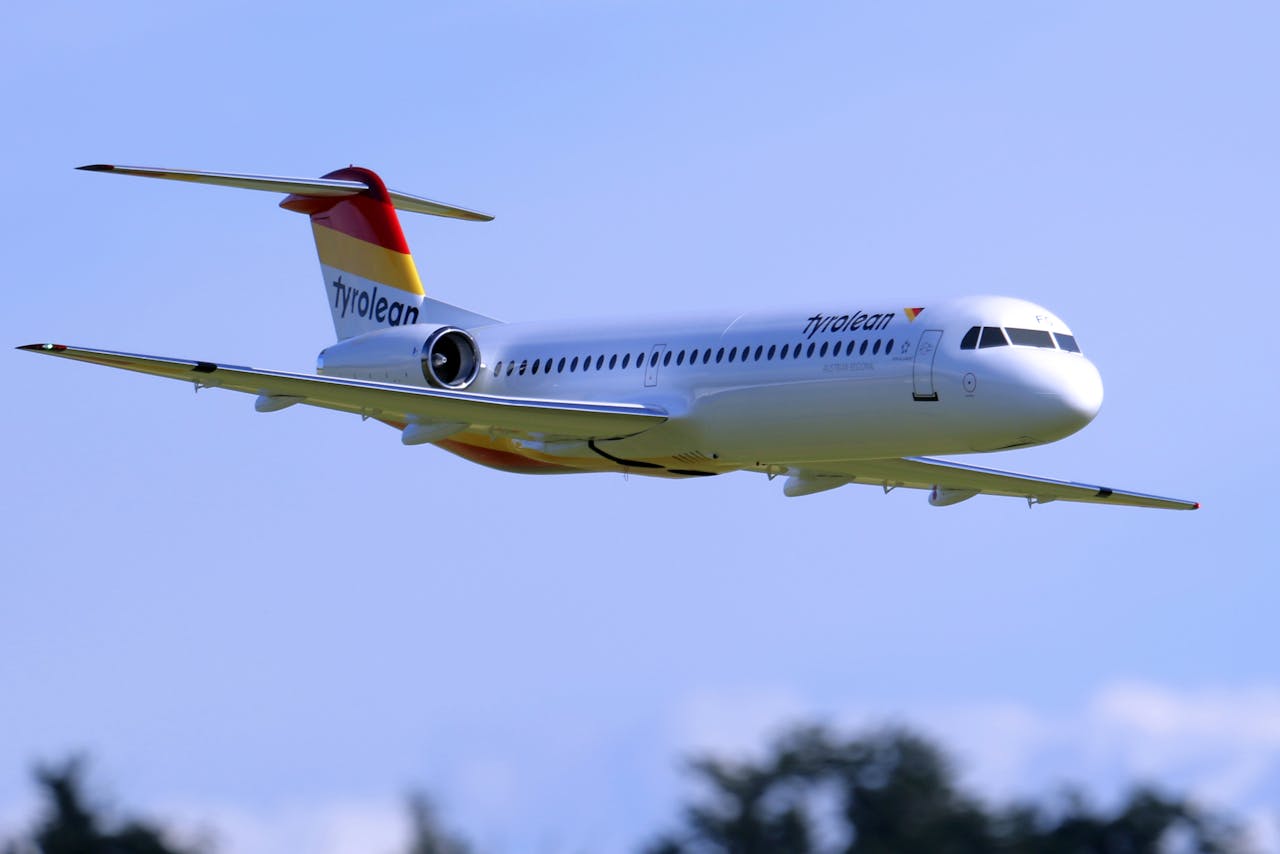 A detailed shot of a radio-controlled Fokker 100 model in flight with Tyrolean livery.